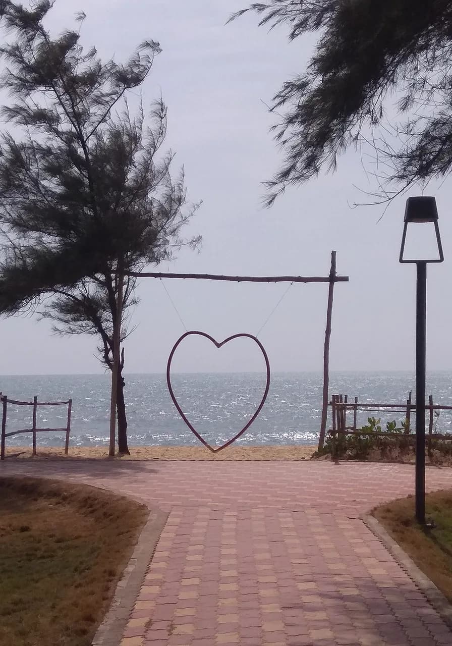 The path through the casuarinas to the heart arch on Padubidri Blue Flag beach, the Arabian Sea beyond