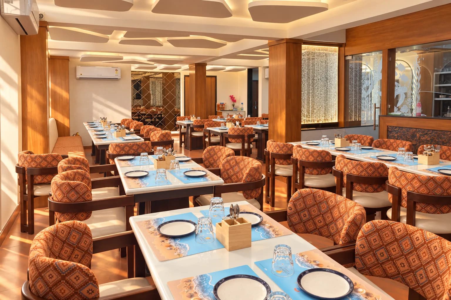 The length of the Sea Swad dining room in natural afternoon light, with white tables and the actual etched sea panel.