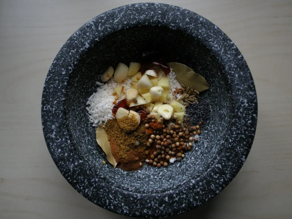Whole spices in a stone mortar, ready to be pounded