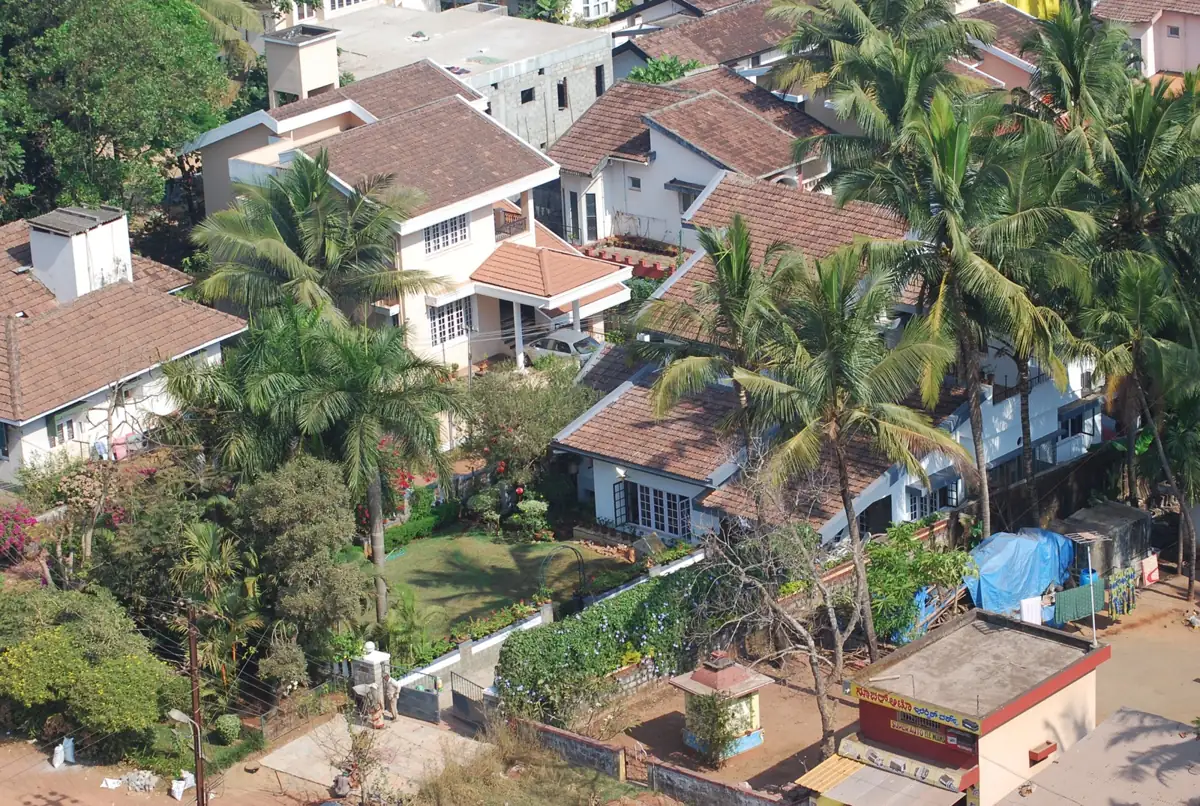 Red Mangalore-tiled rooftops among coconut palms