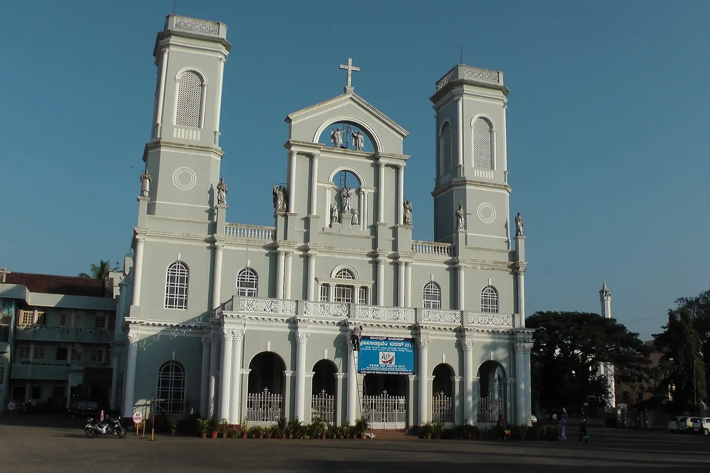 The twin white towers of Milagres Church in Mangaluru against a blue sky